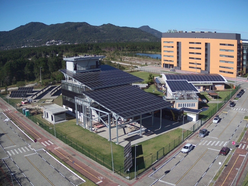 Vista aérea do espaço fotovoltaico da UFSC em Florianópolis, com sistemas de energia solar instalados para pesquisa e formação técnica.